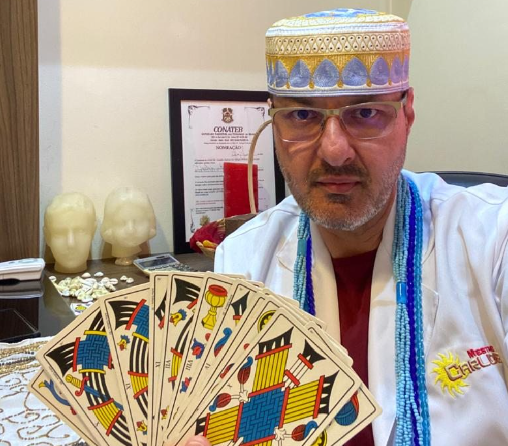 Mestre Carlos segurando as cartas do tarot
